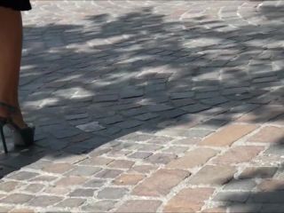 Outdoors candid film of a woman with sexy legs and feet in platform high heels walking around and sitting on a bench to rest her feet.-0