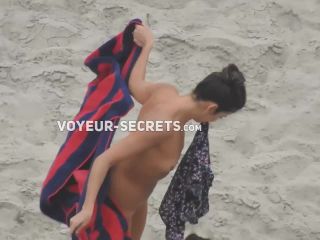 Beautiful woman gets dressed on beach-2